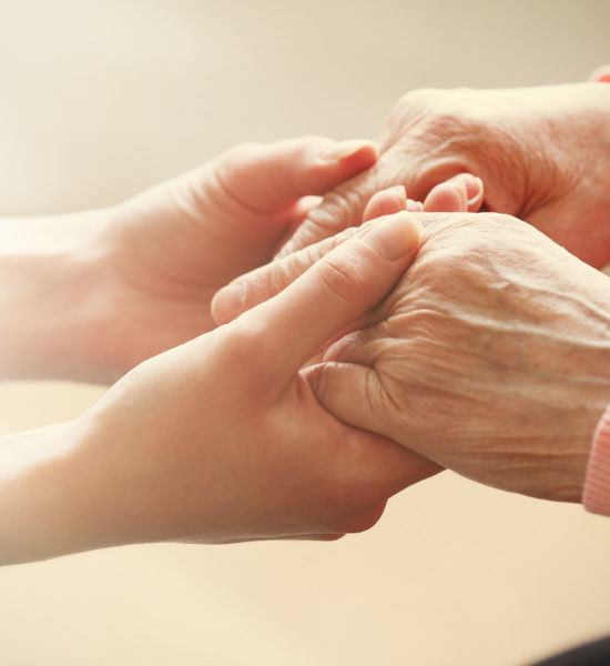 37056637 - old and young holding hands on light background, closeup